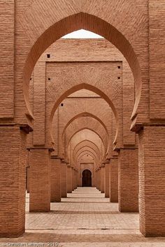 an archway in the middle of a building with brick walls and arches on either side