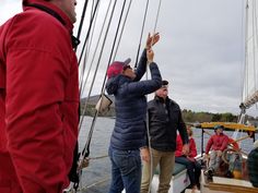 several people on a boat waving to the sky