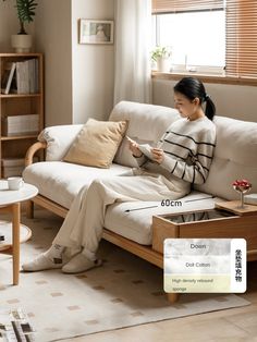 a woman sitting on a couch reading a book