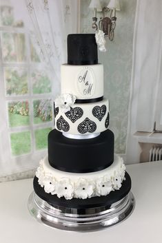 a three tiered wedding cake with black and white decorations