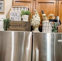 a kitchen with stainless steel refrigerators and wooden crates on the counter top in front of wood paneled cabinets