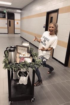 a woman standing next to a table with food on top of it in a hallway