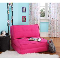 a purple futon bed sitting on top of a hard wood floor next to a window