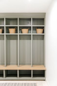 an empty shelf with baskets on it in a room