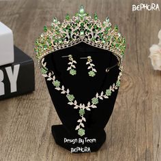 the tiara and earrings are on display in front of a black stand with flowers