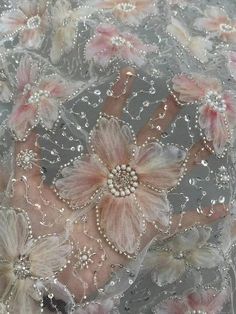 an embroidered fabric with flowers and pearls on the bottom, along with beaded lace