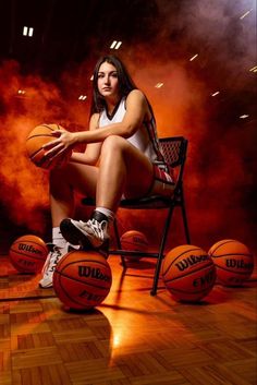 a woman sitting on top of a chair holding a basketball next to three balls in front of her