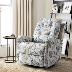 a blue and white chair sitting in a living room next to a book shelf with pictures on it