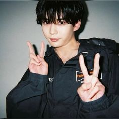 a young man making the peace sign with his fingers