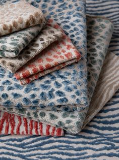 a pile of fabric sitting on top of a blue and white table cloth covered in animal print