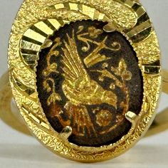 a gold ring with an image of a bird on it