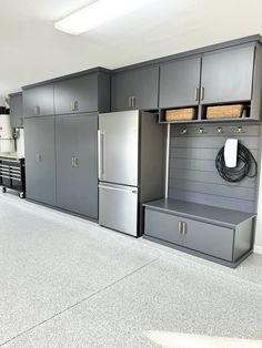 a kitchen with gray cabinets and drawers in the center, under an overhead lighting fixture