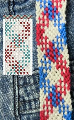 a red, white and blue tie sitting on top of a pair of denim jeans