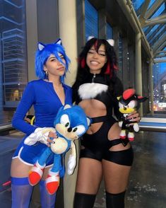 two women dressed up in costumes posing for a photo with stuffed animals and sonic the hedge