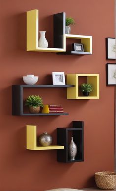 some shelves are arranged on the wall near a vase and potted plant in front of it