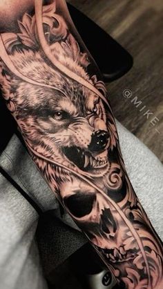 a man's arm with a wolf tattoo on it and an arrow in the middle