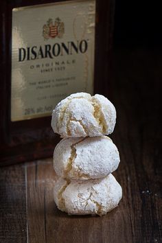 three powdered sugar cookies stacked on top of each other next to a bottle of wine