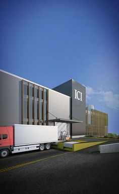 a semi truck is parked in front of a large building with the word ic on it's side