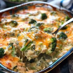 a casserole dish with broccoli and cheese being lifted from the casserole