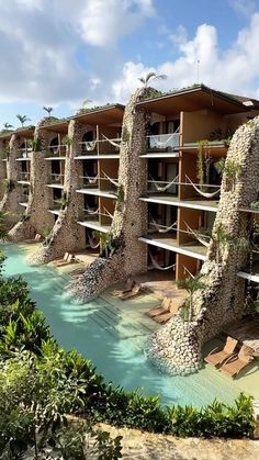 an outdoor swimming pool surrounded by trees and buildings with balconies on each side