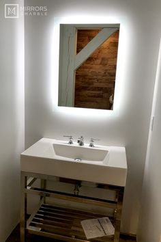 a white sink sitting under a bathroom mirror