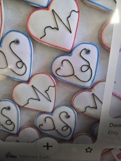 several decorated cookies are on display in a store window, including one with hearts and the other with numbers