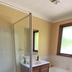 a bathroom with a sink, toilet and bathtub next to a large window in the corner