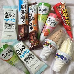 an assortment of snacks including milk, yogurt and ice cream on a bed