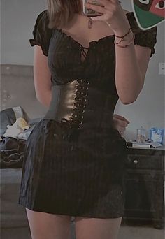 a woman taking a selfie with her cell phone and wearing a corset