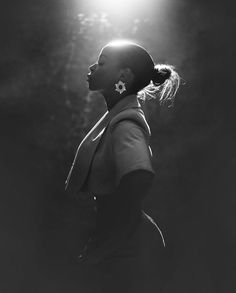 a black and white photo of a woman with her hair in a pony tail bun