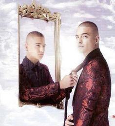 a man in a red suit is looking at himself in a mirror with clouds behind him