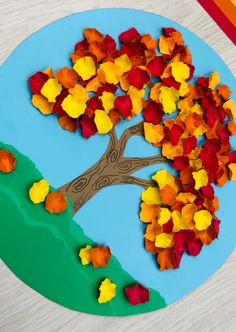 a paper plate that has a tree on it with fall leaves in the shape of a heart