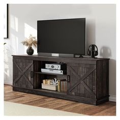 a flat screen tv sitting on top of a wooden entertainment center