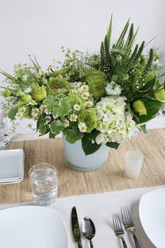 a table set with plates, silverware and flowers