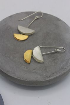 These dangling earrings are part of our 'MoonPhases' collection that consists of a series of necklaces and matching earrings. We have also created partial gold-coated version of the collection in yellow and rose gold finish.  The folded circles that represent half moon phase are cut out of handmade 95% silver sheet, and are etched on surface to create beautiful texture, typical of Karen silver. The folded moon pieces are placed on sterling silver stem which is attached to a long stem hook, so the earrings can move slightly.  All our products are handmade in silver in our workshop in Northern Thailand where we work alongside Karen hill tribe silversmiths. We ship the items from our office in Bangkok, in original packaging, including the tracking number for safer shipping.  Size: 1.8x0.8 cm Half Moon Earrings, Handmade Silver Jewellery, Dangling Earrings, Moon Earrings, Beautiful Textures, Circle Earrings, Silver Jewellery, Half Moon, Matching Earrings