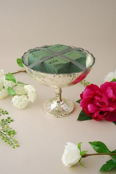 some flowers and a glass dish on a table