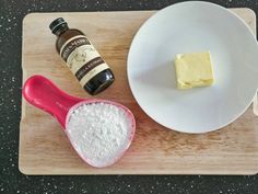 ingredients to make cheesecake sitting on a wooden cutting board next to a white plate