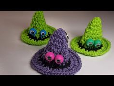 two crocheted hats with googly eyes and one wearing a purple knitted hat