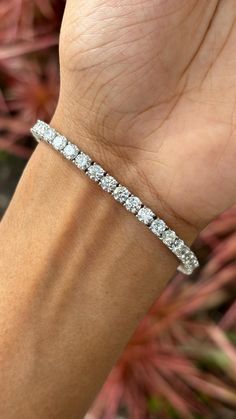 This is one of our most beloved and beautifully handcrafted lab diamond bracelet. This bracelet is studded with 9.42 carat Lab Diamonds that are round-cut. The bracelet is set in 10.95 grams 18K White Gold. The lab-grown diamonds used in this bracelet are created using advanced Chemical Vapor Deposition (CVD) technology, a process we proudly specialize in. These diamonds possess the same physical, chemical, and optical properties as diamonds, ensuring they sparkle with unparalleled brilliance and radiance. Each CVD diamond reflects light beautifully, creating a dazzling display that is indistinguishable from that of natural diamonds. This bracelet is a celebration of both beauty and ethical craftsmanship. Lab-grown diamonds offer a sustainable and environmentally friendly alternative to tr Platinum Diamond Bracelet With Round Cut Accents, Luxury Diamond White Bracelet With Diamond Accents, Platinum Diamond Bracelet With Round Cut, Platinum Diamond Cut Bracelet In Diamond White, Luxury Diamond White Diamond Bracelet For Anniversary, Luxury White Diamond Bracelet With Single Cut Diamonds, Dazzling White Gold Diamond Bracelet, Luxury Diamond White Bracelet For Anniversary, Dazzling White Gold Diamond-cut Bracelet