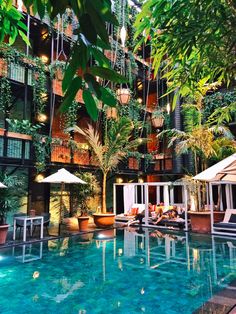 an indoor swimming pool with lounge chairs and umbrellas next to the hotel's lobby