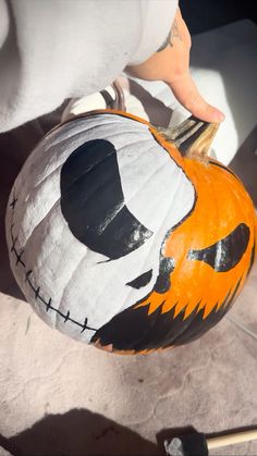 a person is holding a pumpkin decorated like jack - o - lantern