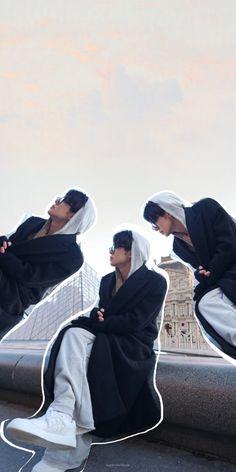 two people dressed in black and white are sitting on a ledge