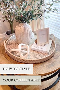 a coffee table with a vase and some books on it next to a potted plant