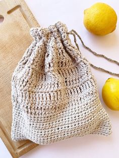 a crocheted bag next to two lemons on a cutting board