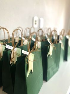 small green bags tied with twine and paper are lined up on a white table