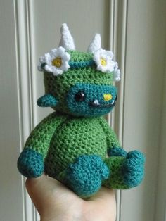 a small crocheted stuffed animal in the palm of a person's hand