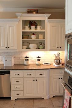 a kitchen with white cabinets and stainless steel appliances