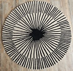 a black and white rug on the floor with lines in the shape of a sunburst