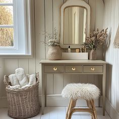 a bathroom with a vanity, mirror and stool next to a basket on the floor