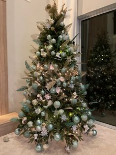 a small christmas tree with silver and green ornaments